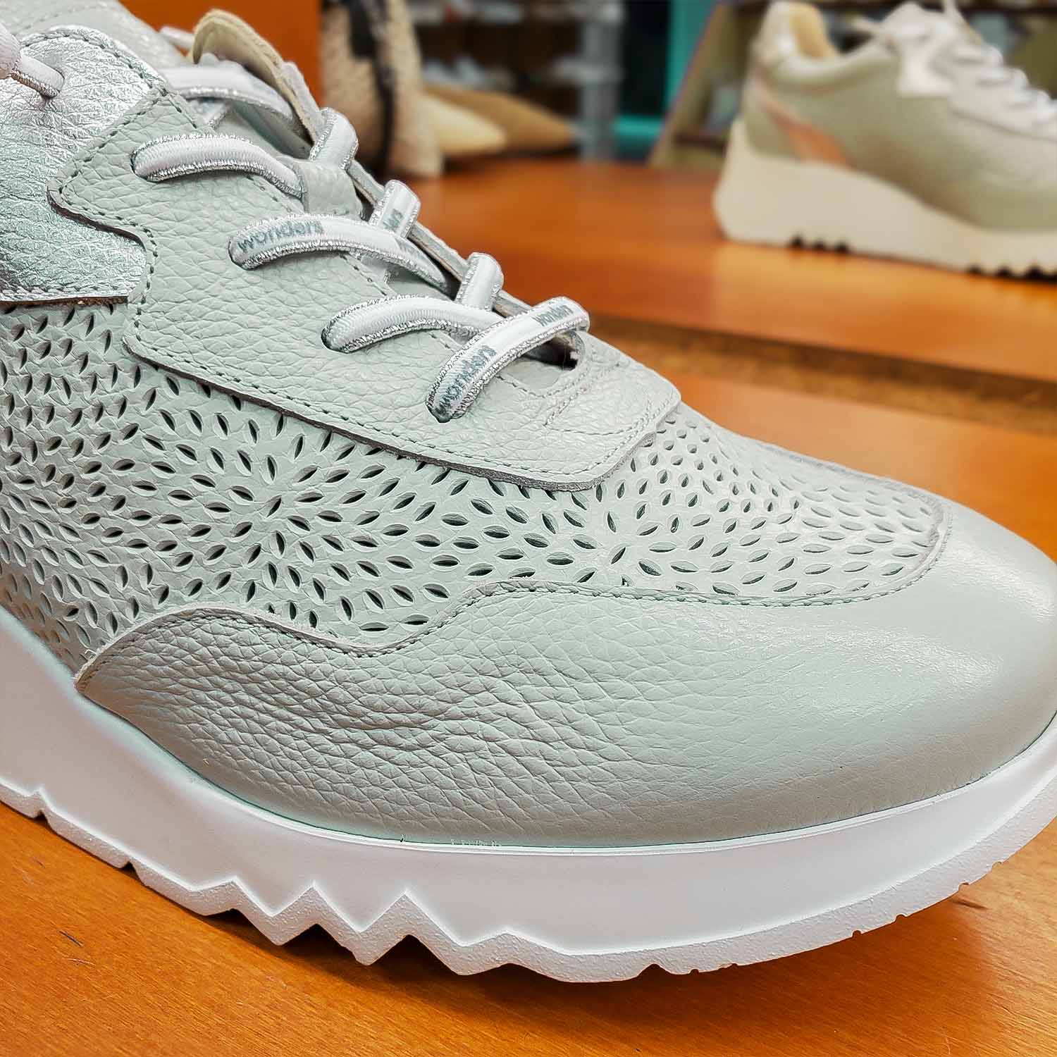 Zbliżenie na cholewkę z naturalnej skóry licowej o ażurowym wzorze skórzanych sneakersów WONDERS, z widocznymi przeszyciami i detalami sznurowania