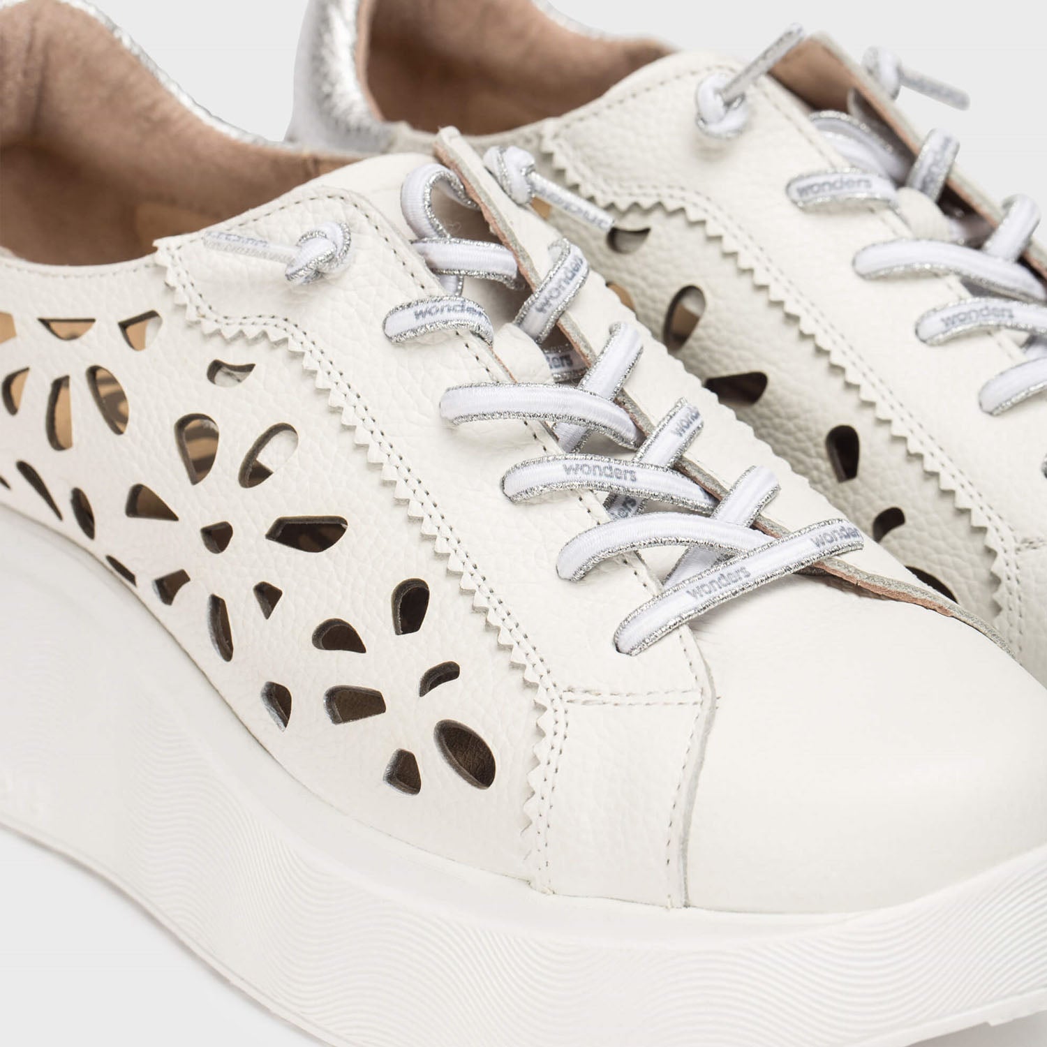 Zbliżenie na białe sneakersy Wonders z ażurową cholewką, prezentujące precyzję wykończenia i charakterystyczną platformę.