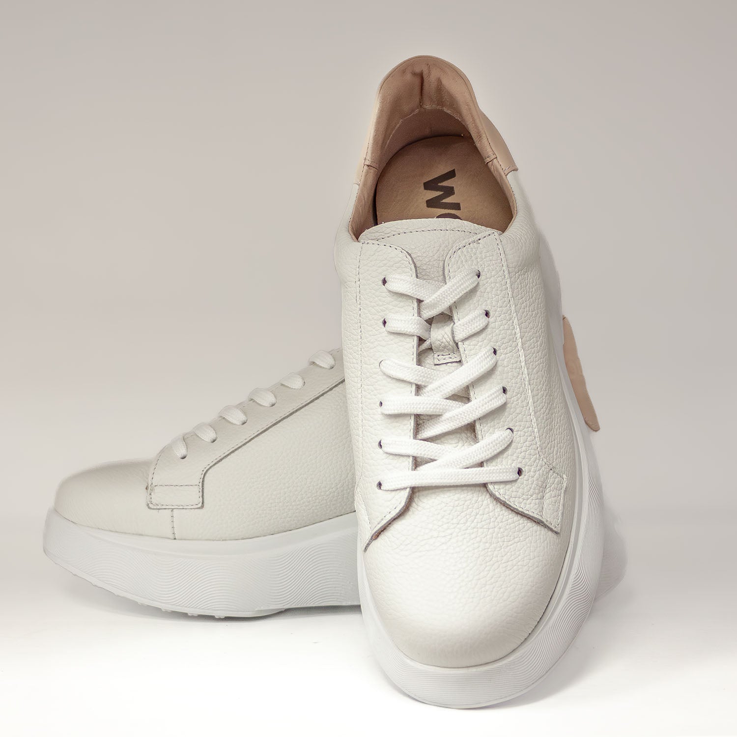 Widok z przodu na białe sneakersy damskie Wonders z miękkiej skóry, na lekkiej platformie.