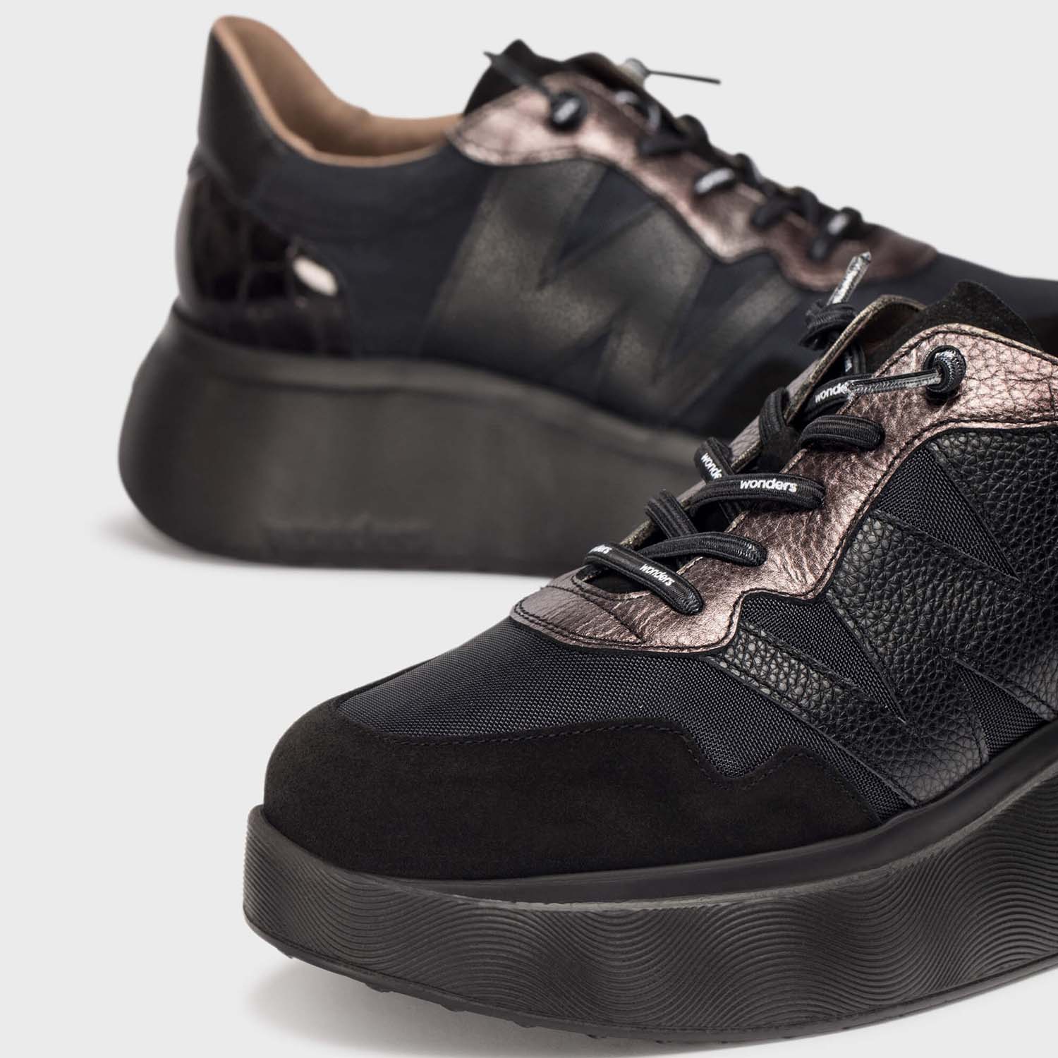 Sneakersy Wonders z jesiennej kolekcji hiszpańskiej marki – czarne, hiszpańskie, eleganckie, zbliżenie na różne faktury cholewki i naturalną skórę.