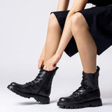 Czarne botki Wonders CAMILA w stylizacji – modelka zapina buty na suwak.