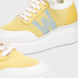 Detal żółtych sneakersów Wonders z technologią WondersFly™ i logotypem.