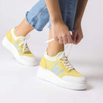 Żółte sneakersy Wonders w stylizacji, zakładane na stopy.
